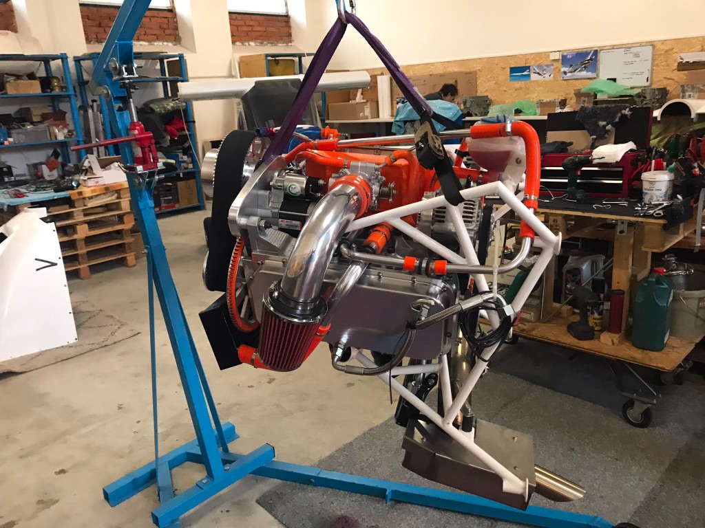 Motor Suzuki zavěšený na jeřábu v dílně